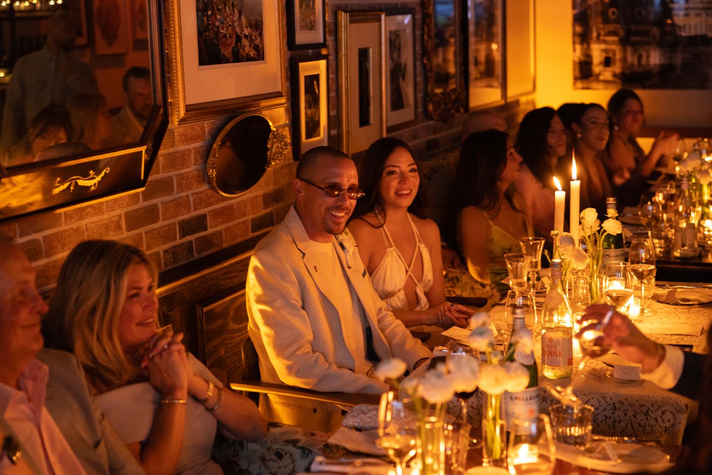 Guests celebrating at a long candlelit table